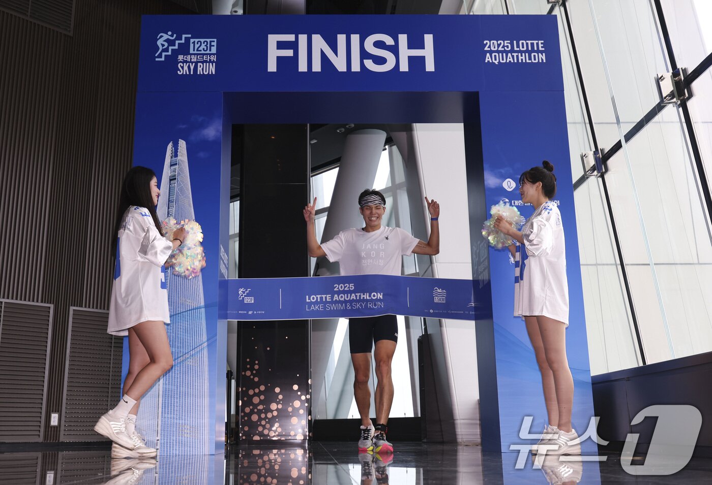 본문 이미지 - 6일 오전 서울 송파구 잠실 롯데월드타워에서 열린 2025 롯데 아쿠아슬론에서 한 참가자가 결승점을 통과하고 있다. &#40;공동취재&#41; 2025.7.6/뉴스1 ⓒ News1 김성진 기자