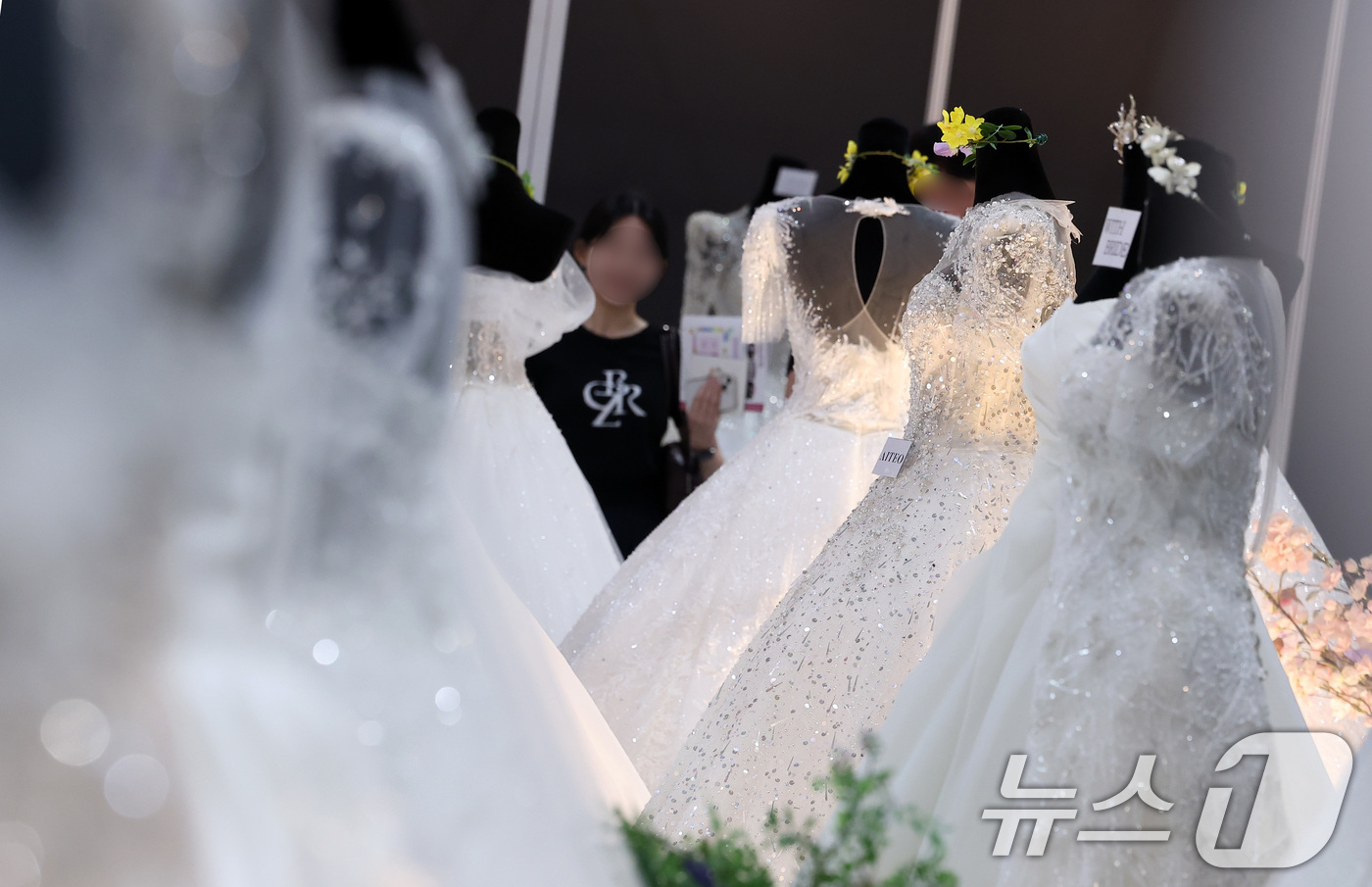 (서울=뉴스1) 김성진 기자 = 6일 서울 강남구 삼성동 코엑스에서 열린 2025 추계 웨덱스 웨딩 박람회에서 예비 부부들이 전시된 드레스를 살펴보고 있다. 2025.7.6/뉴스1 …