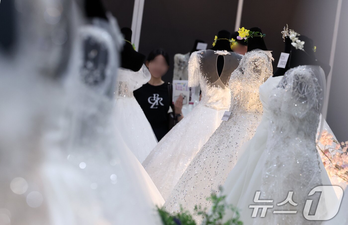 본문 이미지 - 지난달 6일 서울 강남구 삼성동 코엑스에서 열린 2025 추계 웨덱스 웨딩 박람회에서 예비 부부들이 전시된 드레스를 살펴보고 있다. 2025.7.6/뉴스1 ⓒ News1 김성진 기자