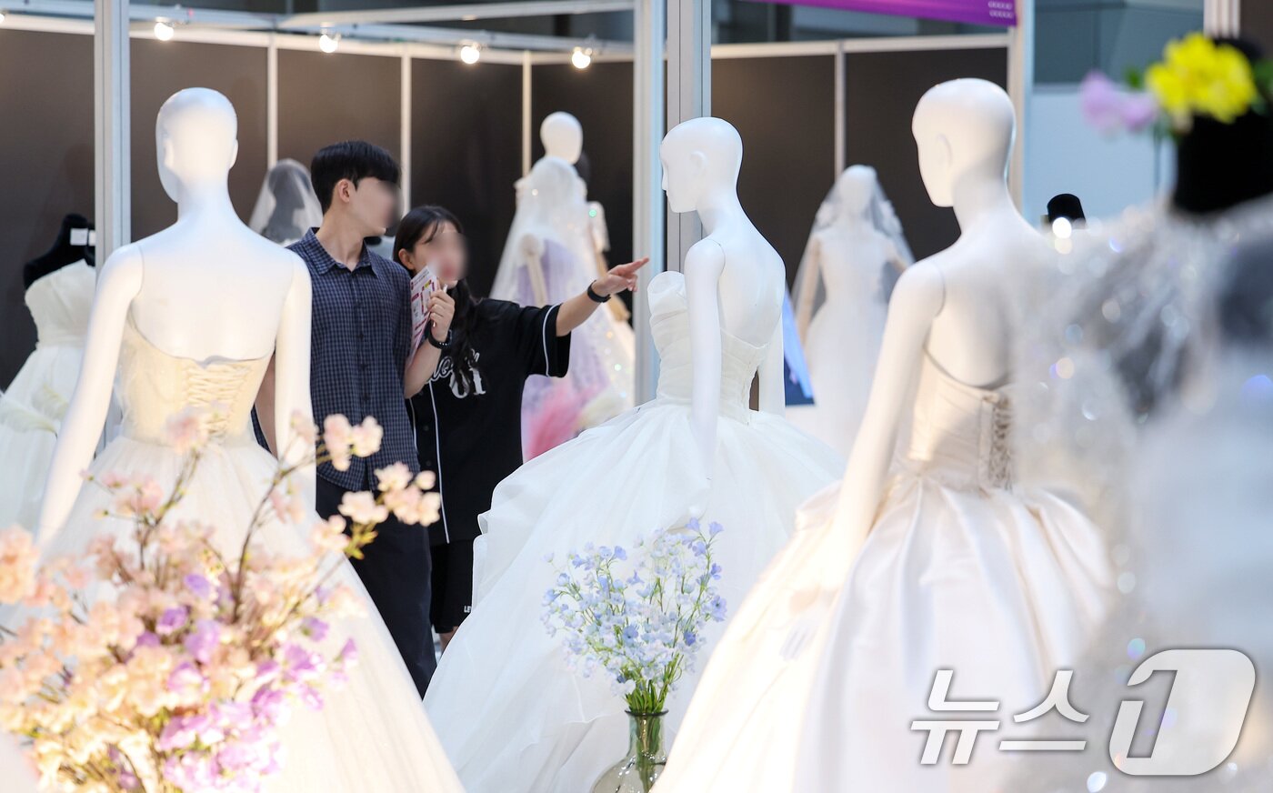 본문 이미지 - 서울 강남구 삼성동 코엑스에서 열린 2025 추계 웨덱스 웨딩 박람회에서 예비 부부들이 전시된 드레스를 살펴보고 있다. 2025.7.6/뉴스1 ⓒ News1 김성진 기자