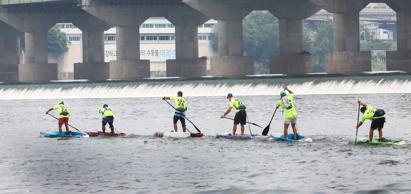 (서울=뉴스1) = 6일 서울 잠실한강공원 수상지역에서 열린 2025 APP월드투어 서울 SUP 오픈 대회에서 남자 프로 9km 장거리 경기 출전 선수들이 열을 지어 잠실 수중보 …