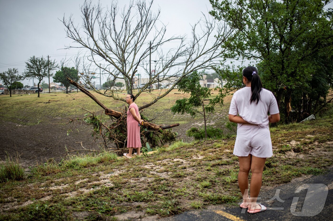 본문 이미지 - 5일(현지시간) 미국 텍사스주 커빌에서 이재민이 피해상황을 살펴보고 있다.ⓒ 로이터=뉴스1