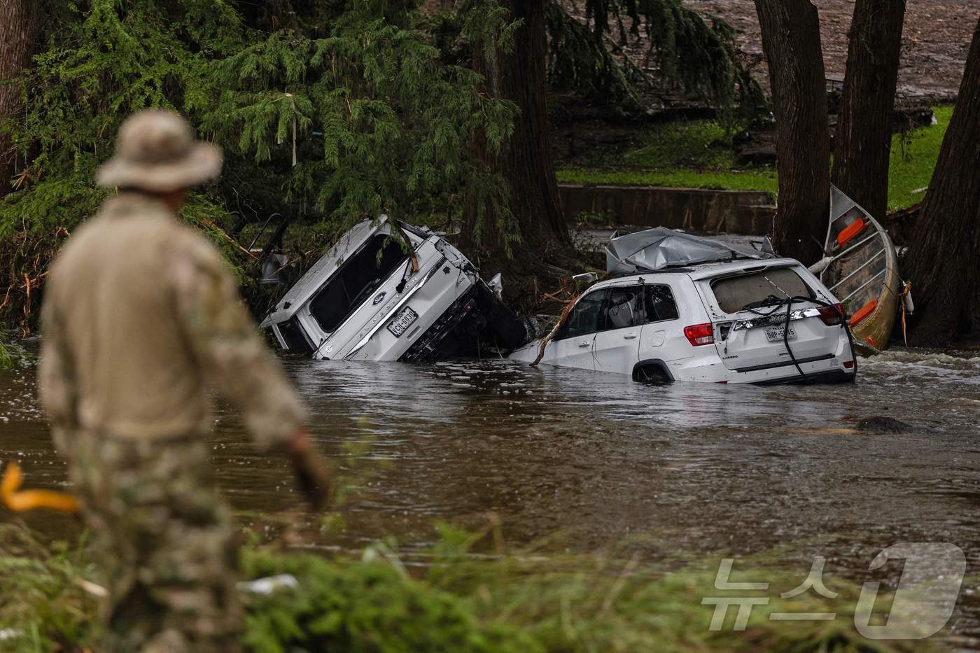 본문 이미지 - 6일(현지시간) 미국 텍사스주 헌트에서 구조대원들이 홍수로 침수된 차량에서 생존자나 유해를 찾기 위해 잔해를 파해치고 있다. ⓒ AFP=뉴스1