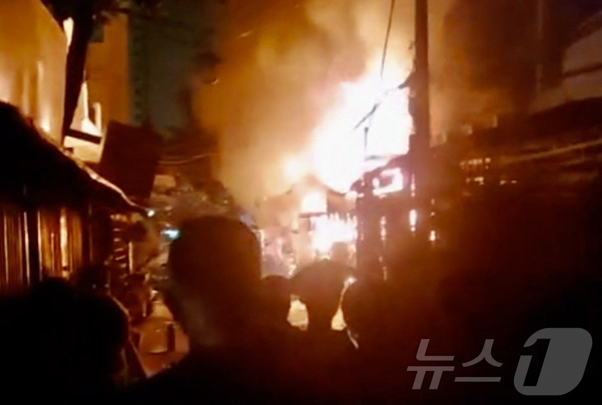 (호치민 AFP=뉴스1) 윤다정 기자 = 6일(현지시간) 밤 베트남 호치민시의 한 아파트에서 발생한 화재를 주민들이 안타깝게 지켜보고 있다. 이 화재로 어린이 2명을 포함해 모두 …