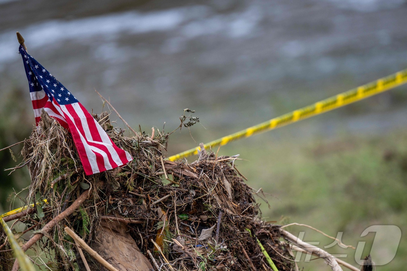 (커빌 AFP=뉴스1) 윤다정 기자 = 6일(현지시간) 미국 텍사스 커빌 과달루페 강변에 설치된 출입 통제선 위로 성조기가 꽂혀 있다. 텍사스를 강타한 폭우와 그에 따른 돌발 홍수 …