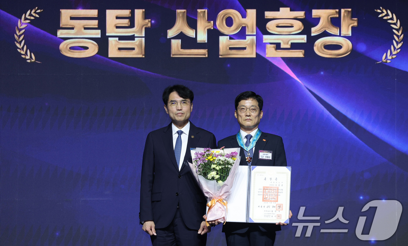 (고양=뉴스1) 김성진 기자 = 권창준 고용노동부 장관 직무대행 차관이 7일 경기 고양시 킨텍스에서 열린 2025 산업안전보건의 달 기념식에서 우종선 삼양식품 생산지원부문장에게 동 …