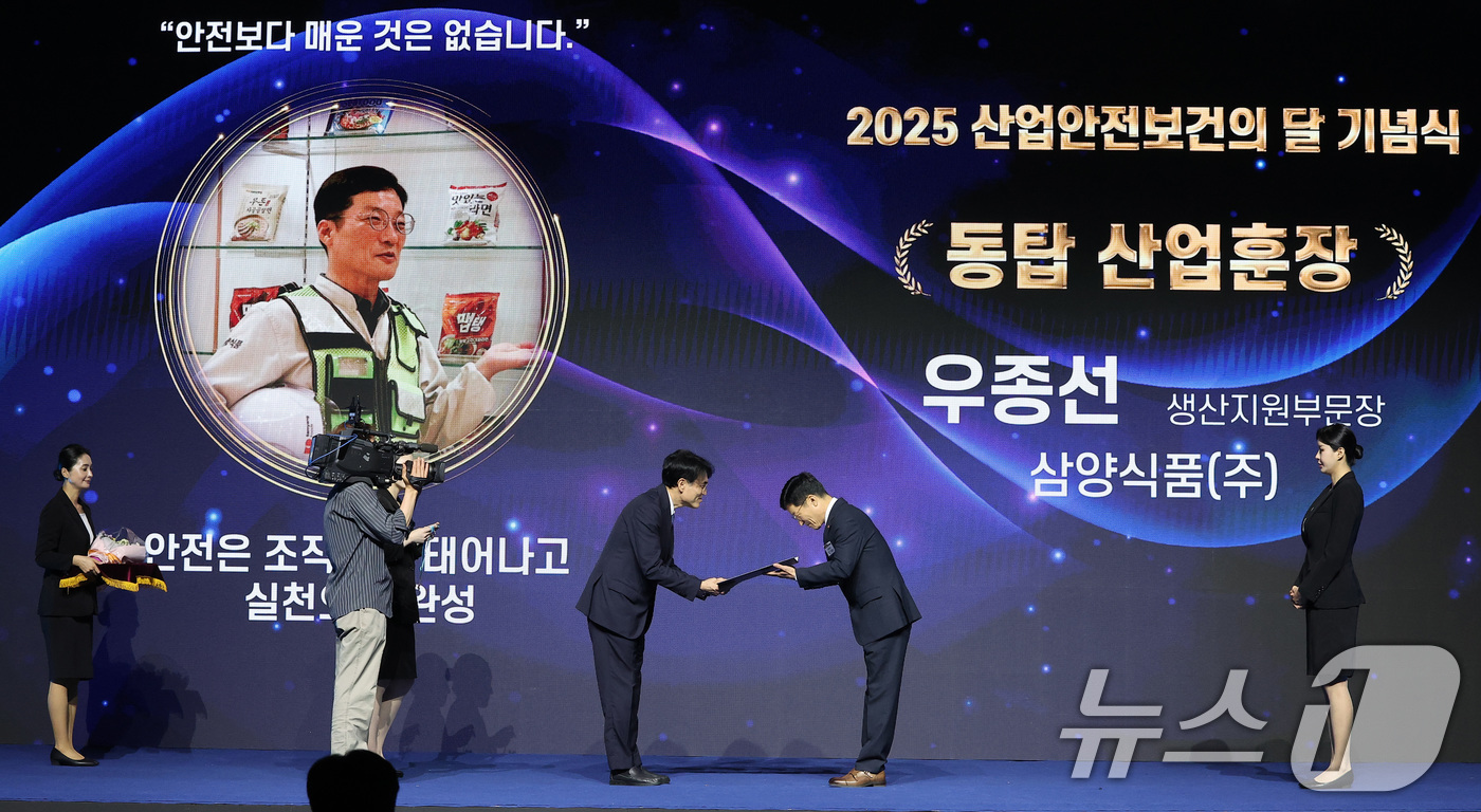 (고양=뉴스1) 김성진 기자 = 권창준 고용노동부 장관 직무대행 차관이 7일 경기 고양시 킨텍스에서 열린 2025 산업안전보건의 달 기념식에서 우종선 삼양식품 생산지원부문장에게 동 …