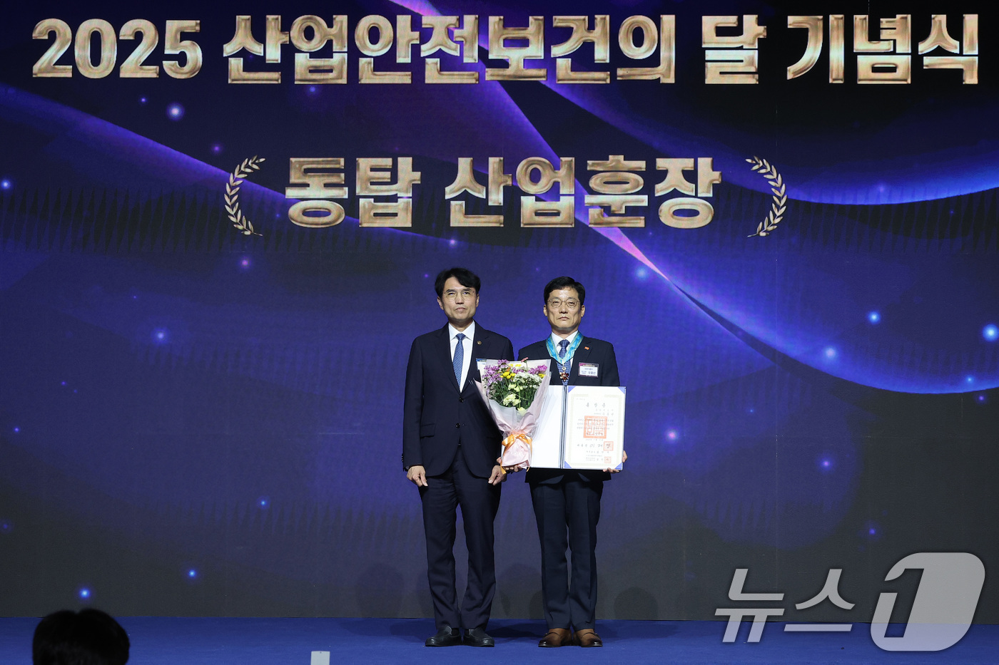 (고양=뉴스1) 김성진 기자 = 권창준 고용노동부 장관 직무대행 차관이 7일 경기 고양시 킨텍스에서 열린 2025 산업안전보건의 달 기념식에서 우종선 삼양식품 생산지원부문장에게 동 …