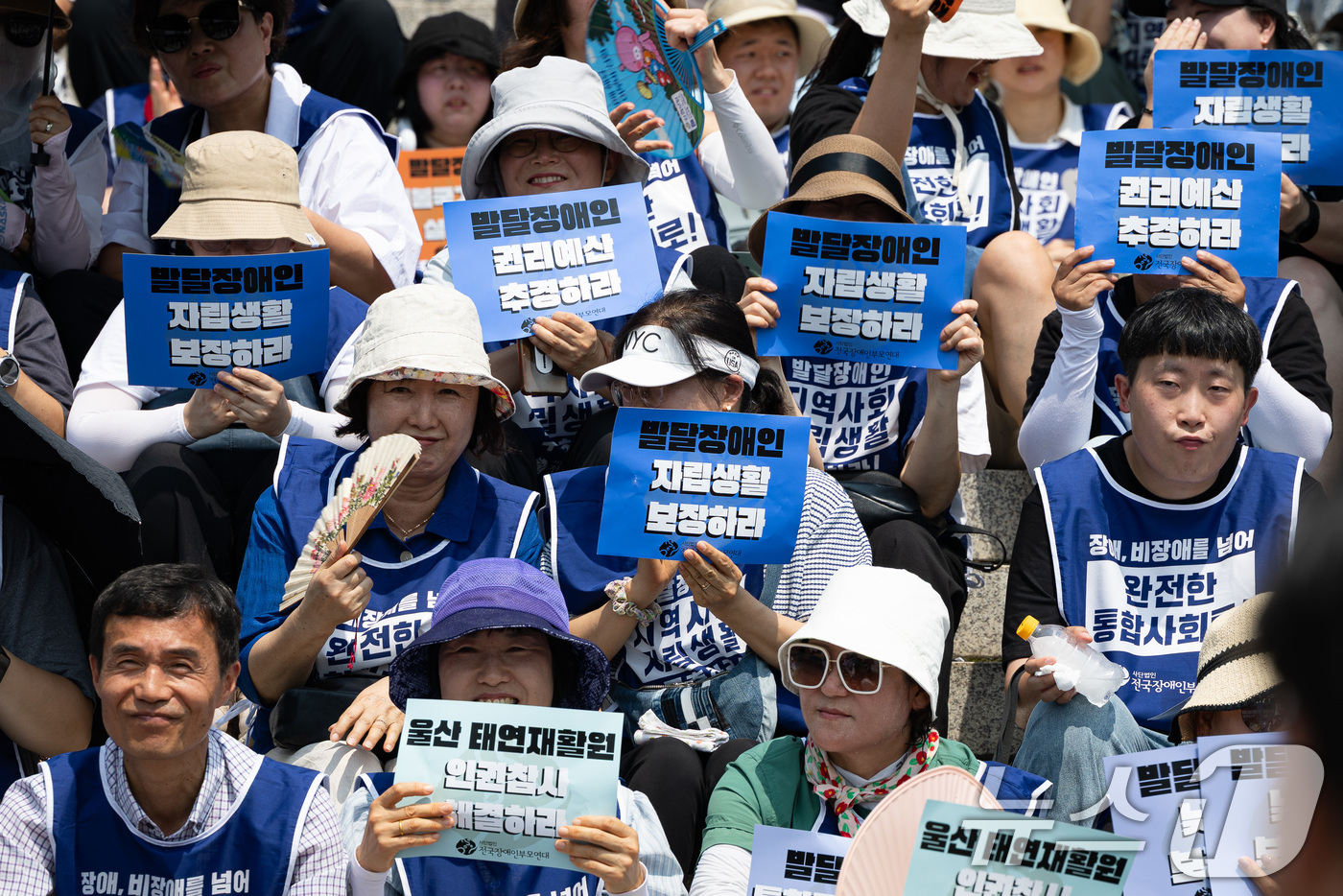 (서울=뉴스1) 유승관 기자 = 8일 서울 여의도 국회 본청 앞에서 열린 발달장애인 권리 확대를 요구하는 오체투지 투쟁 보고대회에서 참석자들이 손팻말을 들고 있다. 2025.7.8 …