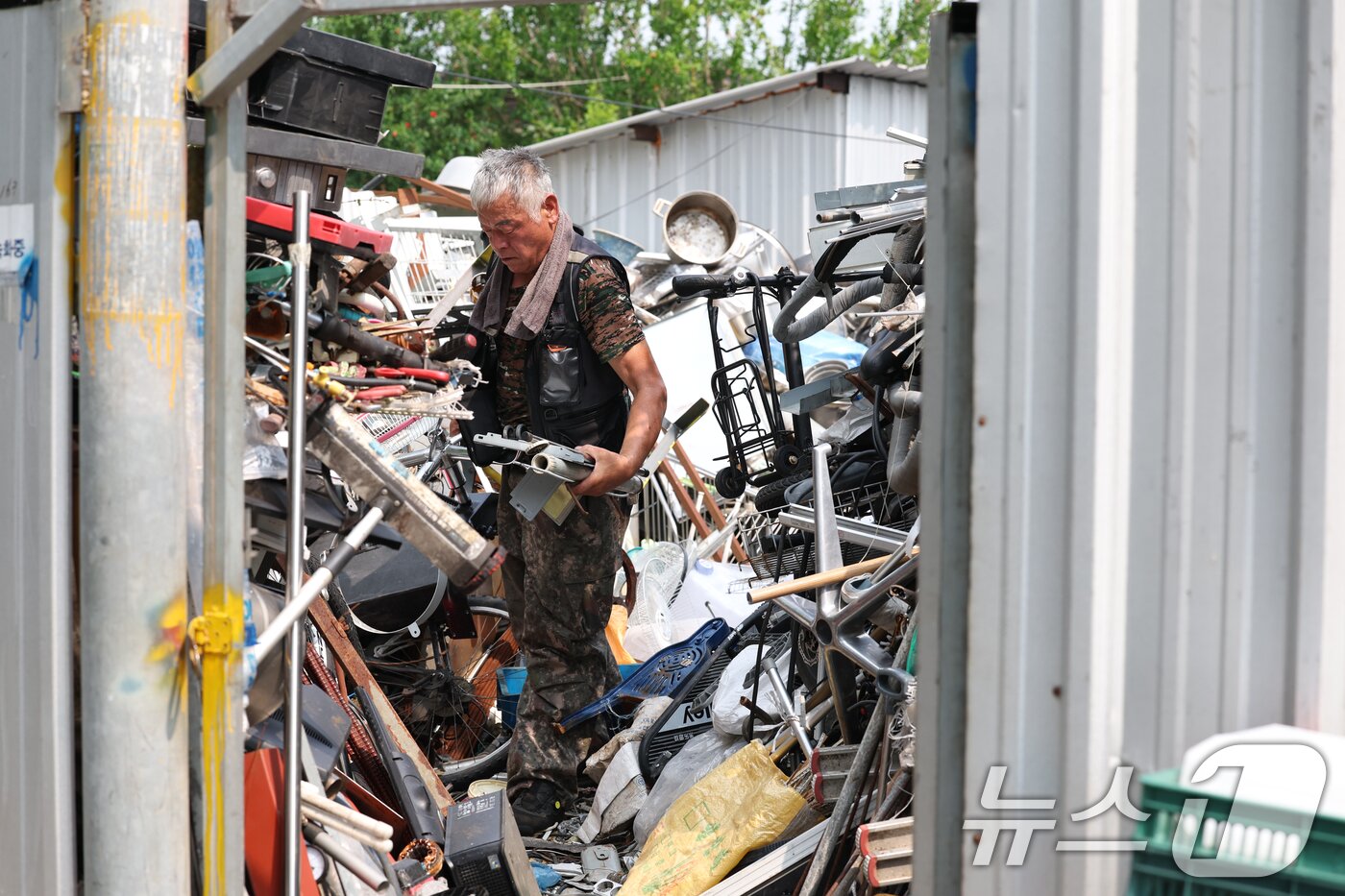 본문 이미지 - 12일째 폭염특보가 이어지고 있는 8일 광주 광산구의 한 고물상에서 근로자가 일을 하고 있다. 2025.7.8/뉴스1 ⓒ News1 이승현 기자