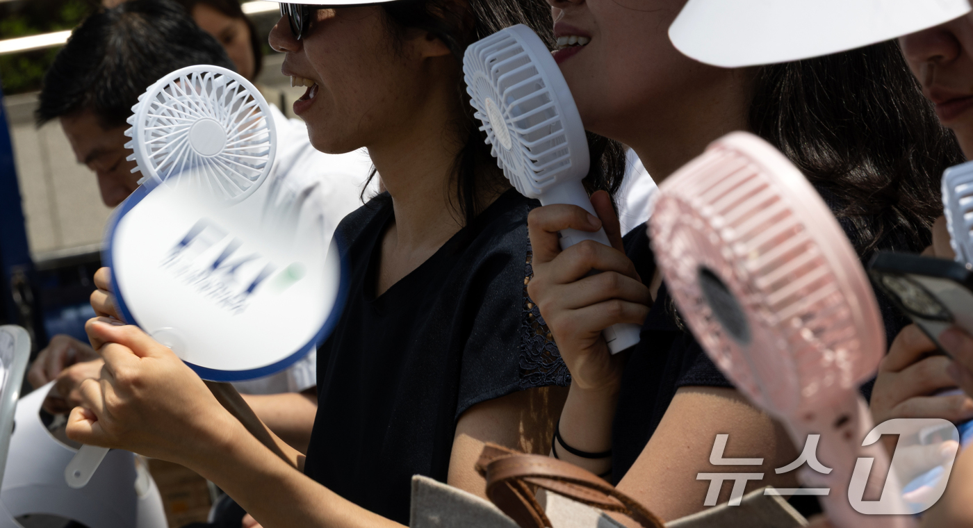 (서울=뉴스1) 이승배 기자 = 8일 오전 서울 중구 청계광장에서 열린 'K-바캉스 캠페인' 개회식 참석자들이 미니 선풍기와 부채로 더위를 식히고 있다.한국경제인협회는 여름 휴가철 …