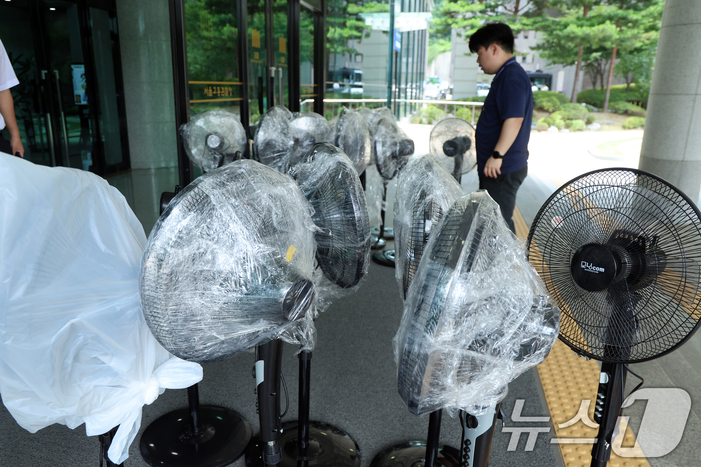 (서울=뉴스1) 황기선 기자 = 전국에 폭염특보가 발효된 8일 오후 서울 서초구 서울고등검찰청에 마련된 조은석 특별검사(내란특검 특검) 사무실 앞에서 관계자들이 선풍기를 특검 사무 …