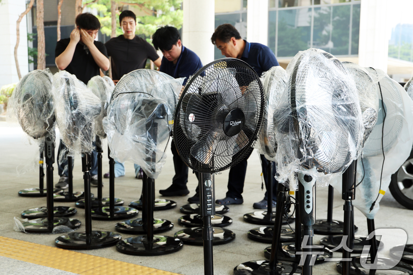 (서울=뉴스1) 황기선 기자 = 전국에 폭염특보가 발효된 8일 오후 서울 서초구 서울고등검찰청에 마련된 조은석 특별검사(내란특검 특검) 사무실 앞에서 관계자들이 선풍기를 특검 사무 …