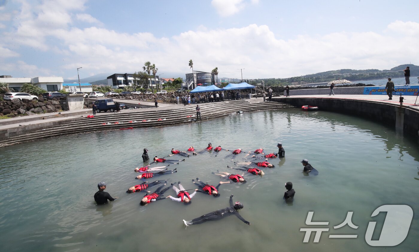 본문 이미지 - 8일 오전 제주 서귀포시 법환어촌계 해녀체험장에서 강정초등학교 학생들이 해녀와 해군 해난구조대&#40;SSU&#41;로부터 &#39;제주형 생존수영&#39; 교육을 받고 있다. 2025.7.8/뉴스1 ⓒ News1 오현지 기자