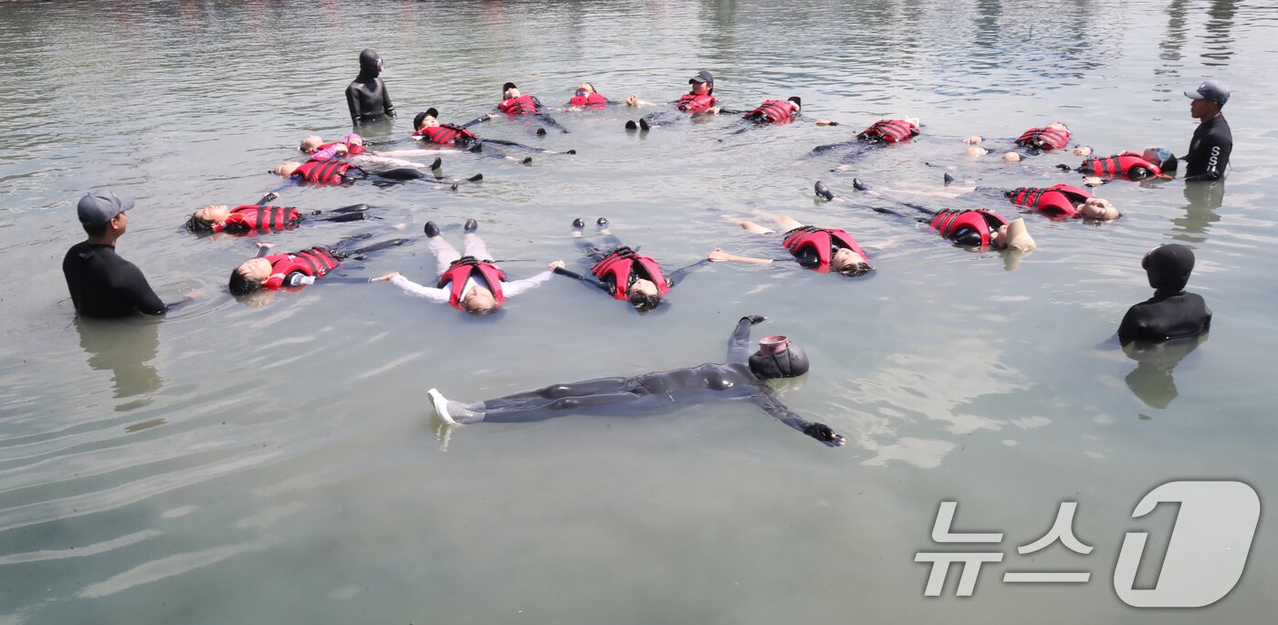 본문 이미지 - 8일 오전 제주 서귀포시 법환어촌계 해녀체험장에서 강정초등학교 학생들이 해녀와 해군 해난구조대&#40;SSU&#41;로부터 &#39;제주형 생존수영&#39; 교육을 받고 있다. 2025.7.8/뉴스1 ⓒ News1 오현지 기자