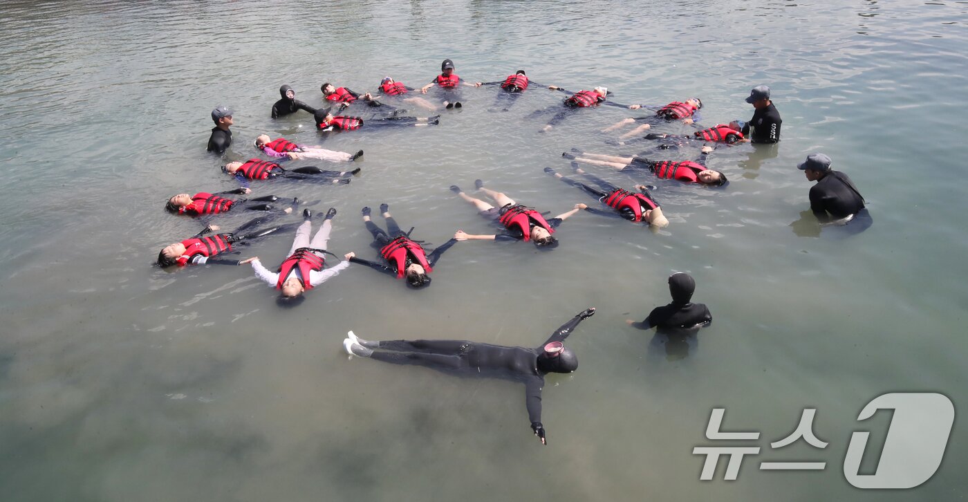 본문 이미지 - 8일 오전 제주 서귀포시 법환어촌계 해녀체험장에서 강정초등학교 학생들이 해녀와 해군 해난구조대&#40;SSU&#41;로부터 &#39;제주형 생존수영&#39; 교육을 받고 있다. 2025.7.8/뉴스1 ⓒ News1 오현지 기자