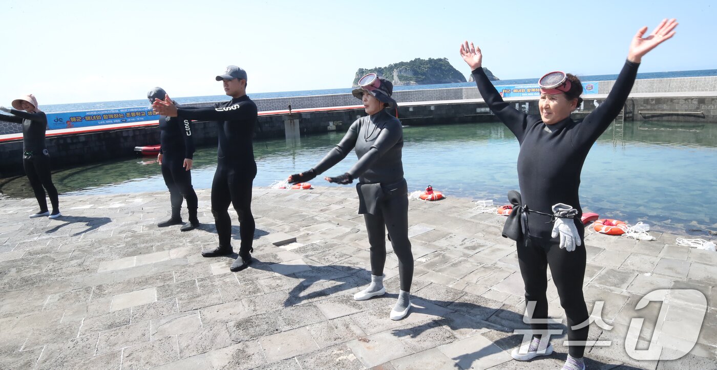 본문 이미지 - 8일 오전 초등학교 생존수영 교육이 진행되는 제주 서귀포시 법환어촌계 해녀체험장에서 생존수영 강사로 나선 해녀와 해군 해난구조대&#40;SSU&#41; 대원들이 몸을 풀고 있다. 2025.7.8/뉴스1 ⓒ News1 오현지 기자