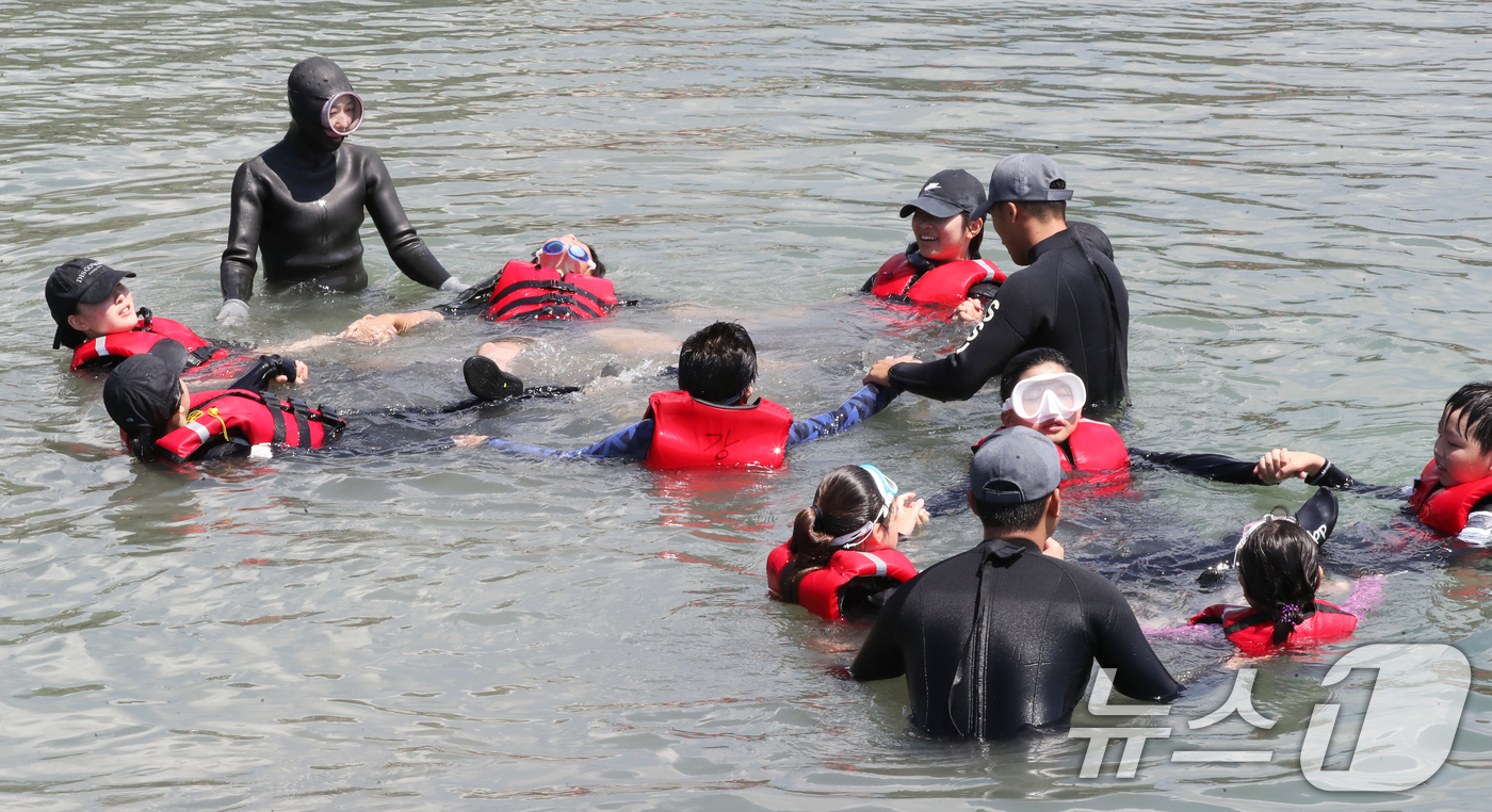(서귀포=뉴스1) 오현지 기자 = 8일 오전 제주 서귀포시 법환어촌계 해녀체험장에서 강정초등학교 학생들이 해녀와 해군 해난구조대(SSU)로부터 '제주형 생존수영' 교육을 받고 있다 …