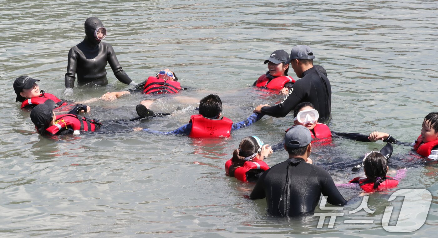 본문 이미지 - 8일 오전 제주 서귀포시 법환어촌계 해녀체험장에서 강정초등학교 학생들이 해녀와 해군 해난구조대&#40;SSU&#41;로부터 &#39;제주형 생존수영&#39; 교육을 받고 있다. 2025.7.8/뉴스1 ⓒ News1 오현지 기자