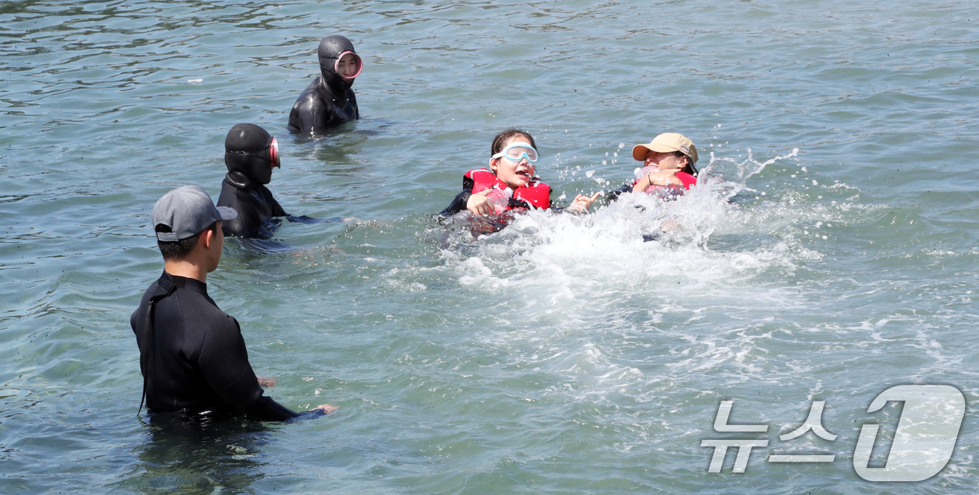 (서귀포=뉴스1) 오현지 기자 = 8일 오전 제주 서귀포시 법환어촌계 해녀체험장에서 강정초등학교 학생들이 해녀와 해군 해난구조대(SSU)로부터 '제주형 생존수영' 교육을 받고 있다 …