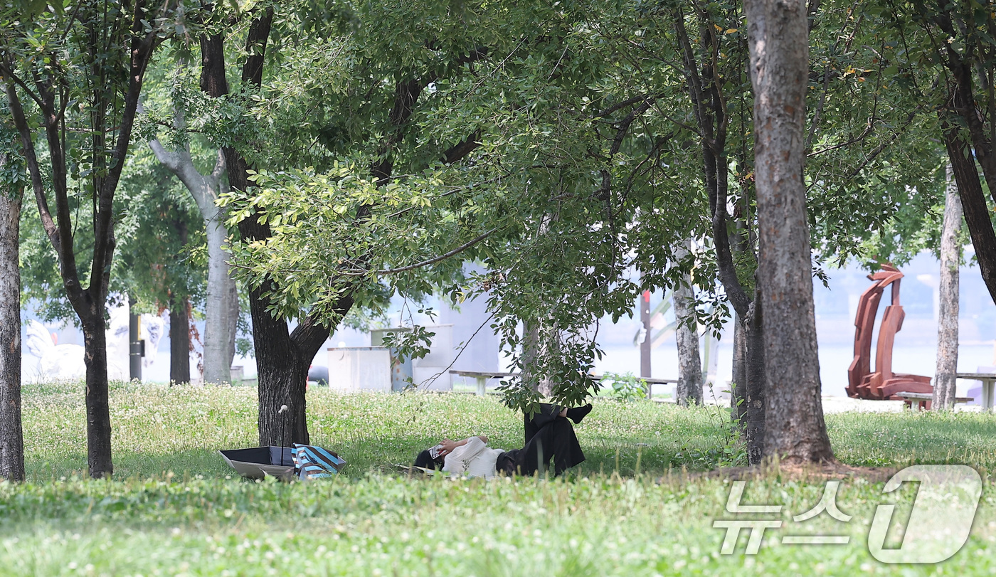 (서울=뉴스1) 김성진 기자 = 전국 대부분 지역에서 최고 체감온도가 35도 안팎으로 오르며 무더운 날씨가 이어진 8일 서울 영등포구 여의도공원을 찾은 시민 시민이 무더위를 피하고 …