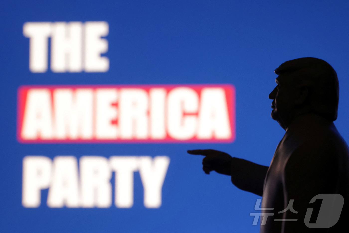 (로이터=뉴스1) 김경민 기자 = 도널드 트럼프 미국 대통령 미니어쳐가 일론 머스크가 창당을 선언한 '미국당' 글씨를 쳐다보고 있다. 2025.7.7ⓒ 로이터=뉴스1