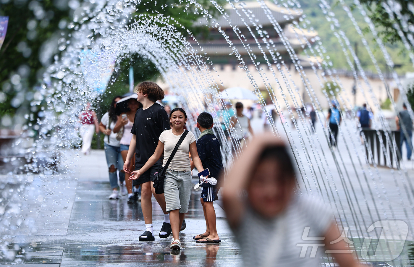 (서울=뉴스1) 김도우 기자 = 폭염이 이어지고 있는 9일 서울 종로구 광화문광장을 찾은 관광객이 바닥분수에서 더위를 식히고 있다. 2025.7.9/뉴스1