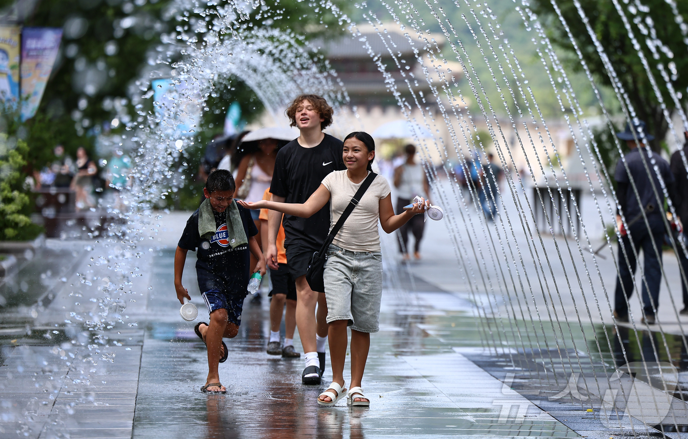 (서울=뉴스1) 김도우 기자 = 폭염이 이어지고 있는 9일 서울 종로구 광화문광장을 찾은 관광객이 바닥분수에서 더위를 식히고 있다. 2025.7.9/뉴스1