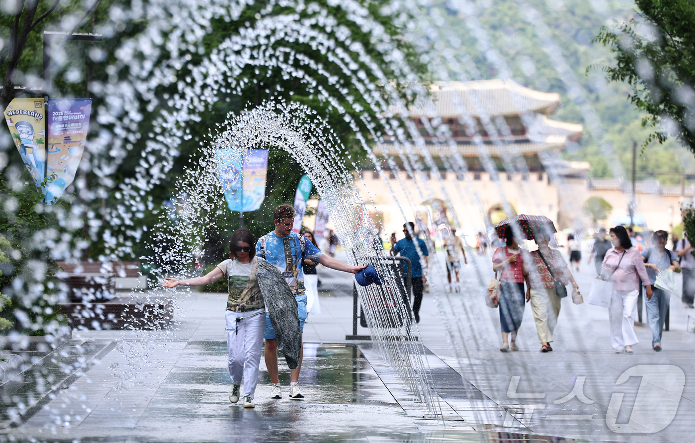 (서울=뉴스1) 김도우 기자 = 폭염이 이어지고 있는 9일 서울 종로구 광화문광장을 찾은 관광객이 바닥분수에서 더위를 식히고 있다. 2025.7.9/뉴스1