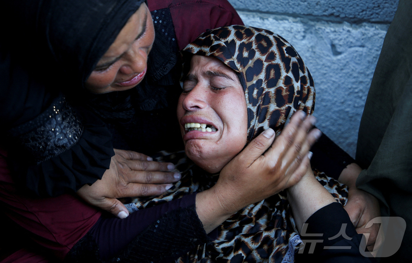 (칸유니스 로이터=뉴스1) 김경민 기자 = 가자지구 남부 칸유니스에 있는 나세르병원에서 이스라엘의 공격으로 사망한 팔레스타인인들의 장례식에서 사람들이 울고 있다. 2025.7.9ⓒ …