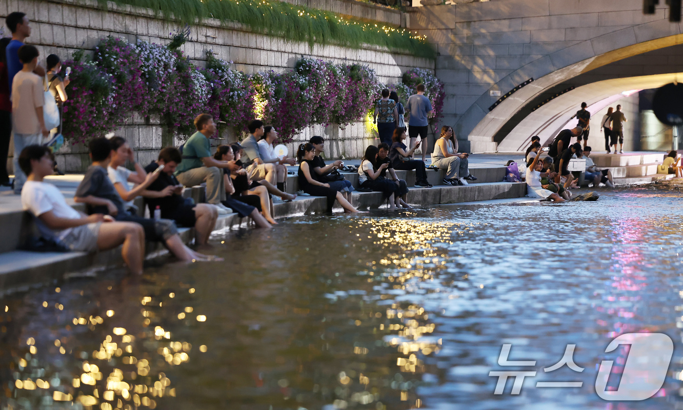 (서울=뉴스1) 장수영 기자 = 이른 폭염과 함께 열흘 넘게 열대야가 이어지고 있는 9일 저녁 서울 중구 청계천을 찾은 시민들이 더위를 식히고 있다. 2025.7.9/뉴스1