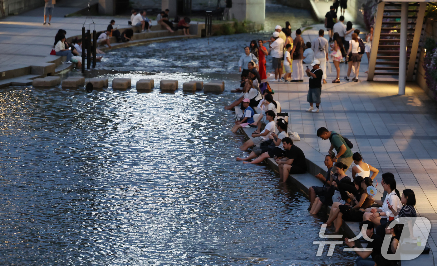 (서울=뉴스1) 장수영 기자 = 이른 폭염과 함께 열흘 넘게 열대야가 이어지고 있는 9일 저녁 서울 중구 청계천을 찾은 시민들이 더위를 식히고 있다. 2025.7.9/뉴스1