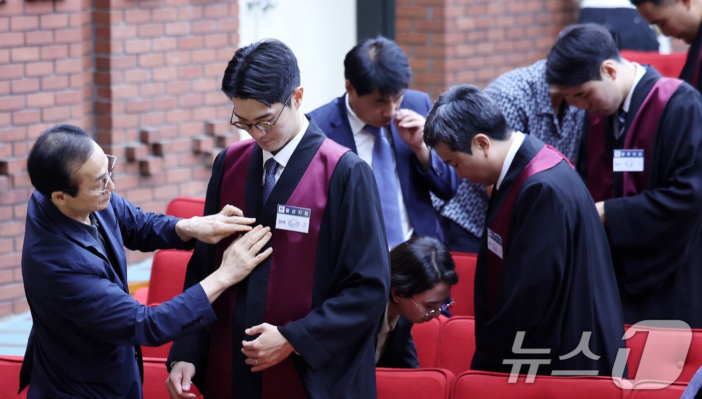 본문 이미지 - 1일 경기 과천 정부과천청사 법무부에서 열린 신임검사 임관식에서 부모님들이 신임 검사들에게 법복을 입혀주고 있다. 2025.8.1/뉴스1 ⓒ News1 박지혜 기자
