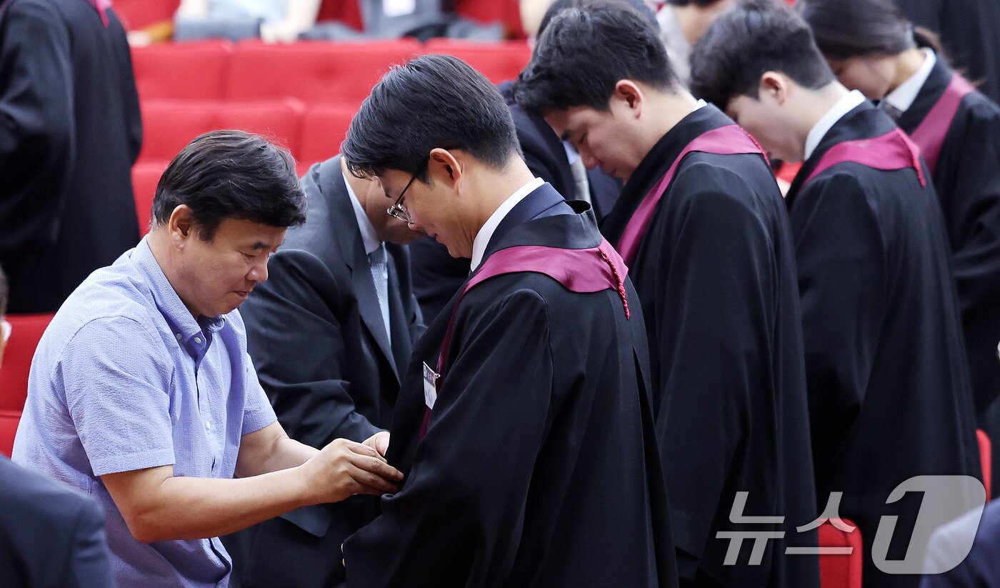 본문 이미지 - 1일 경기 과천 정부과천청사 법무부에서 열린 신임검사 임관식에서 부모님들이 신임 검사들에게 법복을 입혀주고 있다. 2025.8.1/뉴스1 ⓒ News1 박지혜 기자