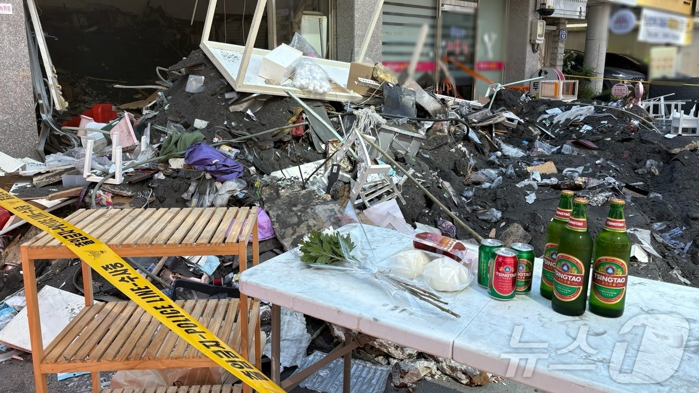 (창원=뉴스1) 강정태 기자 = 1일 오전 경남 창원시 마산회원구 양덕동 2층짜리 상가주택 붕괴 현장에 사망자를 추모하는 국화꽃 한송이와 맥주가 놓여져 있다. 2025.8.1/뉴스 …