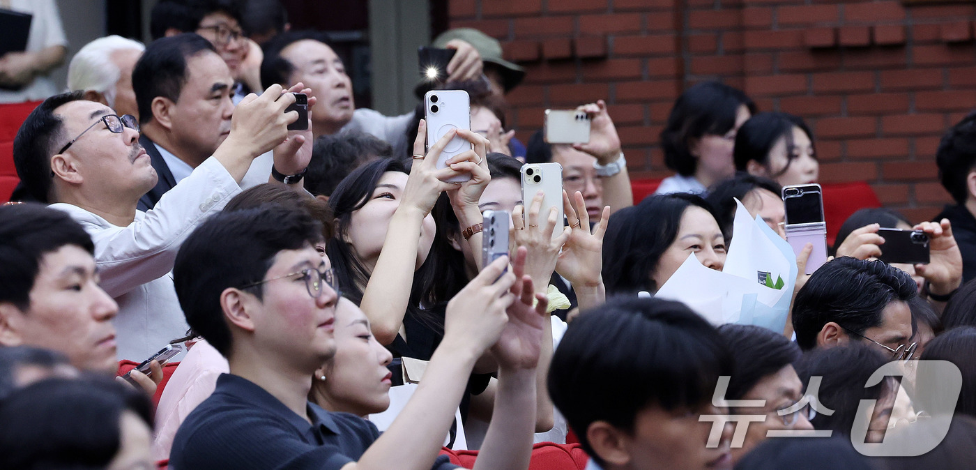 (과천=뉴스1) 박지혜 기자 = 1일 경기 과천 정부과천청사 법무부에서 열린 2025 하반기 신임검사 임관식에 참석한 신임 검사 가족들이 자랑스러운 순간을 스마트폰에 담고 있다. …