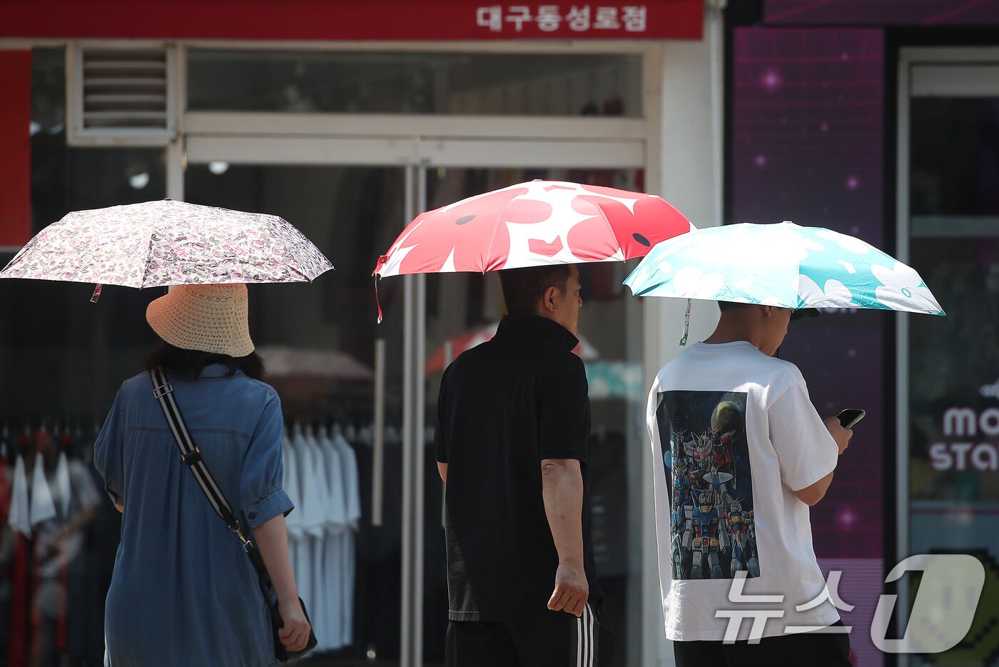 본문 이미지 - 폭염이 계속된 1일 대구 중구 동성로에서 시민들이 양산을 펼쳐 뙤약볕을 가린 채 발걸음을 옮기고 있다. 2025.8.1/뉴스1 ⓒ News1 공정식 기자