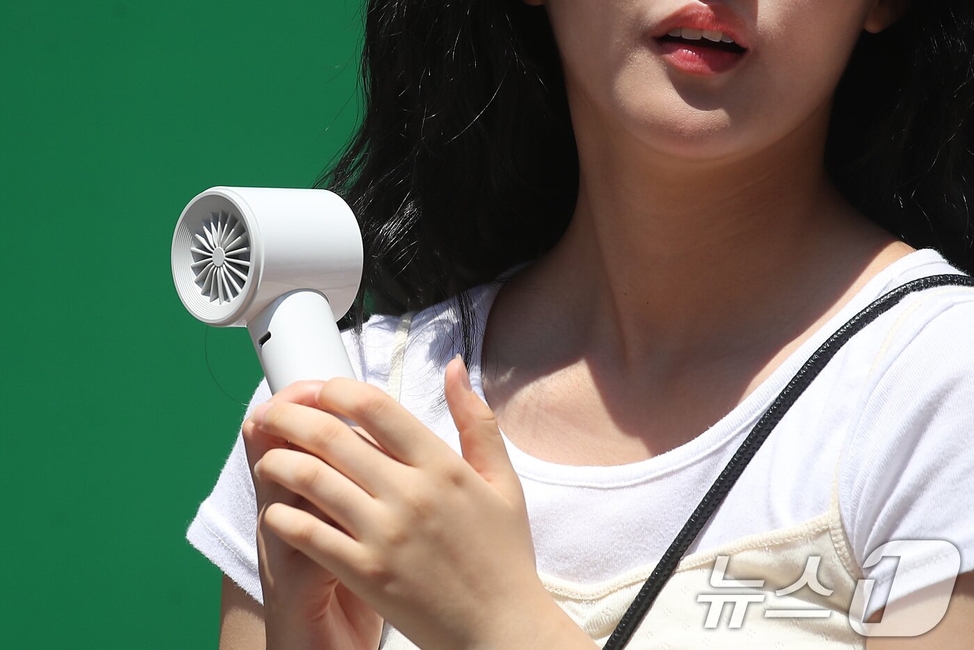 본문 이미지 - 폭염이 계속된 1일 대구 중구 동성로에서 한 시민이 휴대용 선풍기 바람을 맞으며 발걸음을 옮기고 있다. 2025.8.1/뉴스1 ⓒ News1 공정식 기자