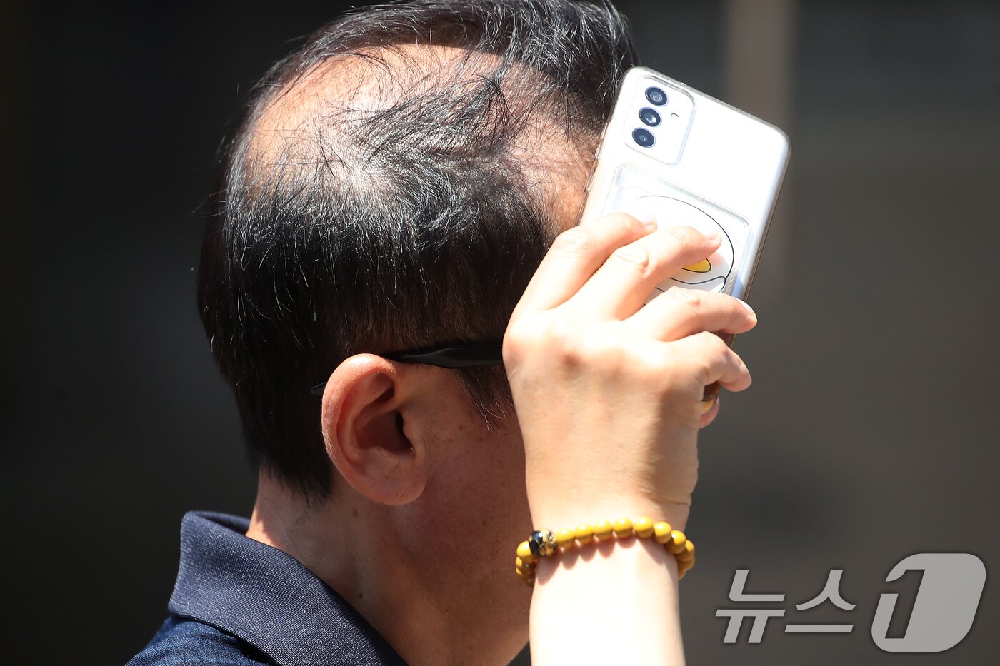 본문 이미지 - 폭염이 계속된 1일 대구 중구 동성로에서 한 시민이 휴대전화로 뙤약볕을 가린 채 발걸음을 옮기고 있다. 2025.8.1/뉴스1 ⓒ News1 공정식 기자