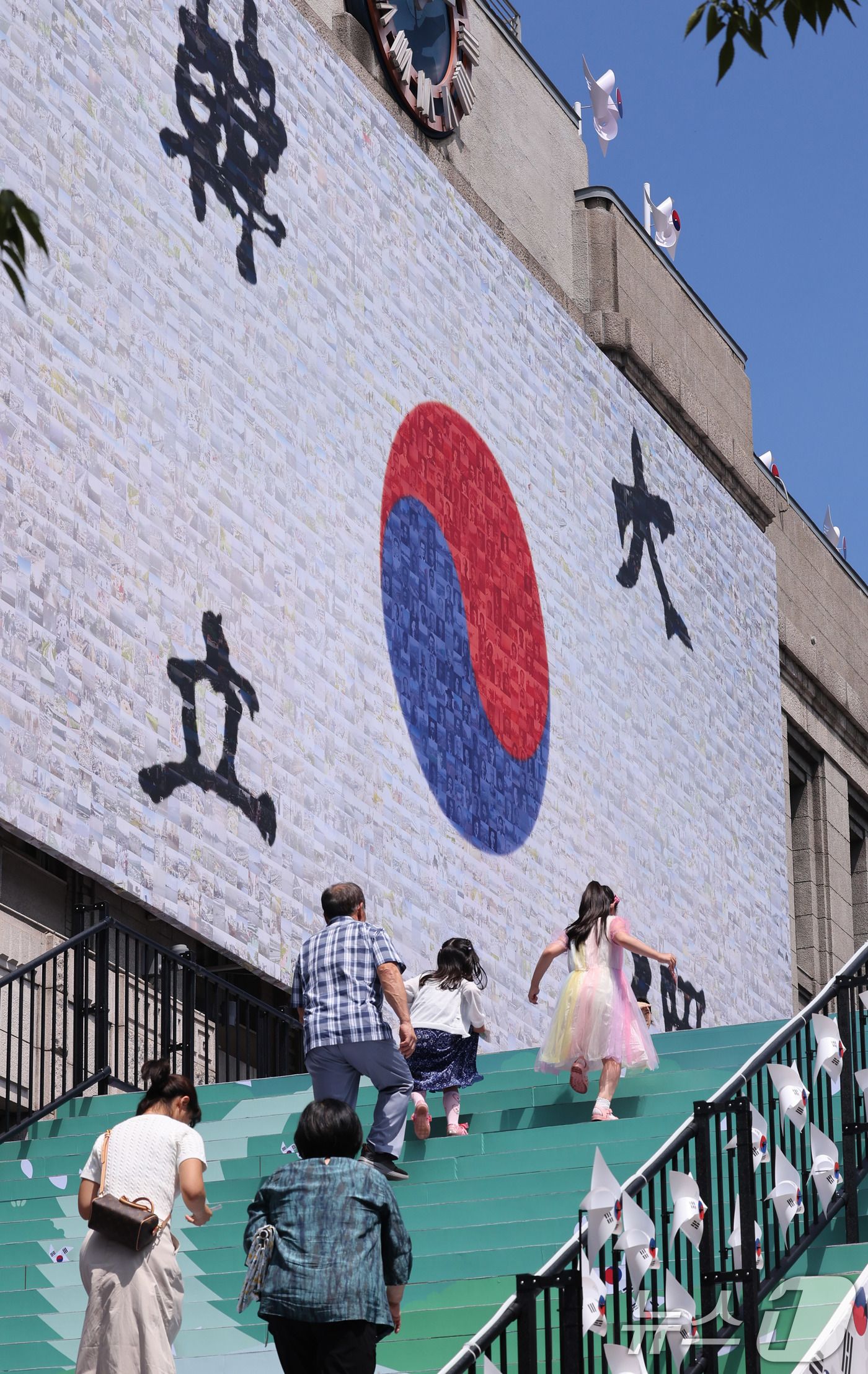 (서울=뉴스1) 박지혜 기자 = 제80주년 광복절을 앞둔 10일 서울 중구 서울도서관 입구에 마련된 태극기 언덕을 시민들이 오르고 있다.태극기 언덕은 광복의 자부심과 기쁨을 형상화 …