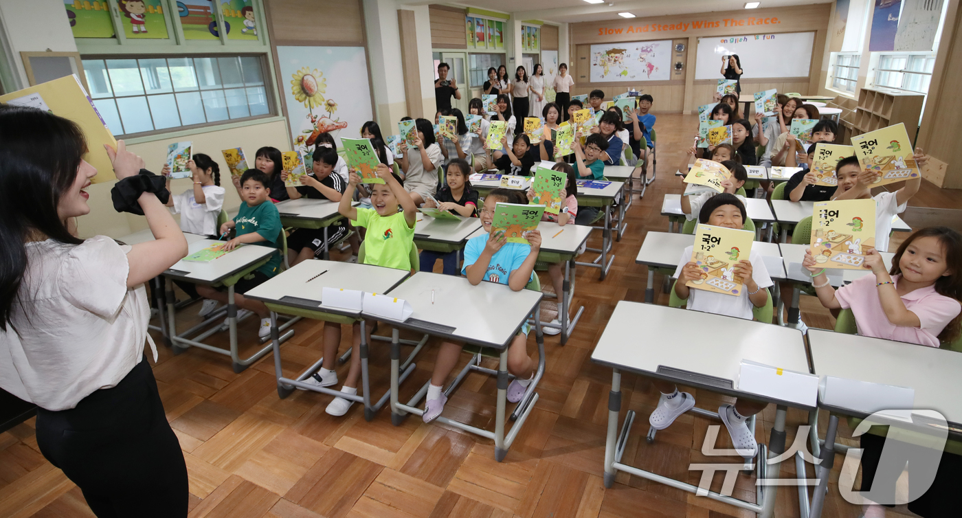 (부산=뉴스1) 윤일지 기자 = 11일 여름방학을 마치고 개학한 부산 사상구 모동초등학교에서 학생들이 새학기 교과서를 들어 보이고 있다.  2025.8.11/뉴스1