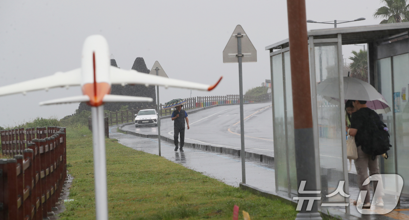 (제주=뉴스1) 오현지 기자 = 제주에 비가 내리면서 폭염특보가 모두 해제된 11일 오전 제주시 용담해안도로에서 우산을 쓴 관광객들이 발걸음을 옮기고 있다. 2025.8.11/뉴스 …