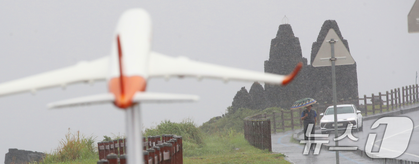 (제주=뉴스1) 오현지 기자 = 제주에 비가 내리면서 폭염특보가 모두 해제된 11일 오전 제주시 용담해안도로에서 우산을 쓴 관광객들이 발걸음을 옮기고 있다. 2025.8.11/뉴스 …