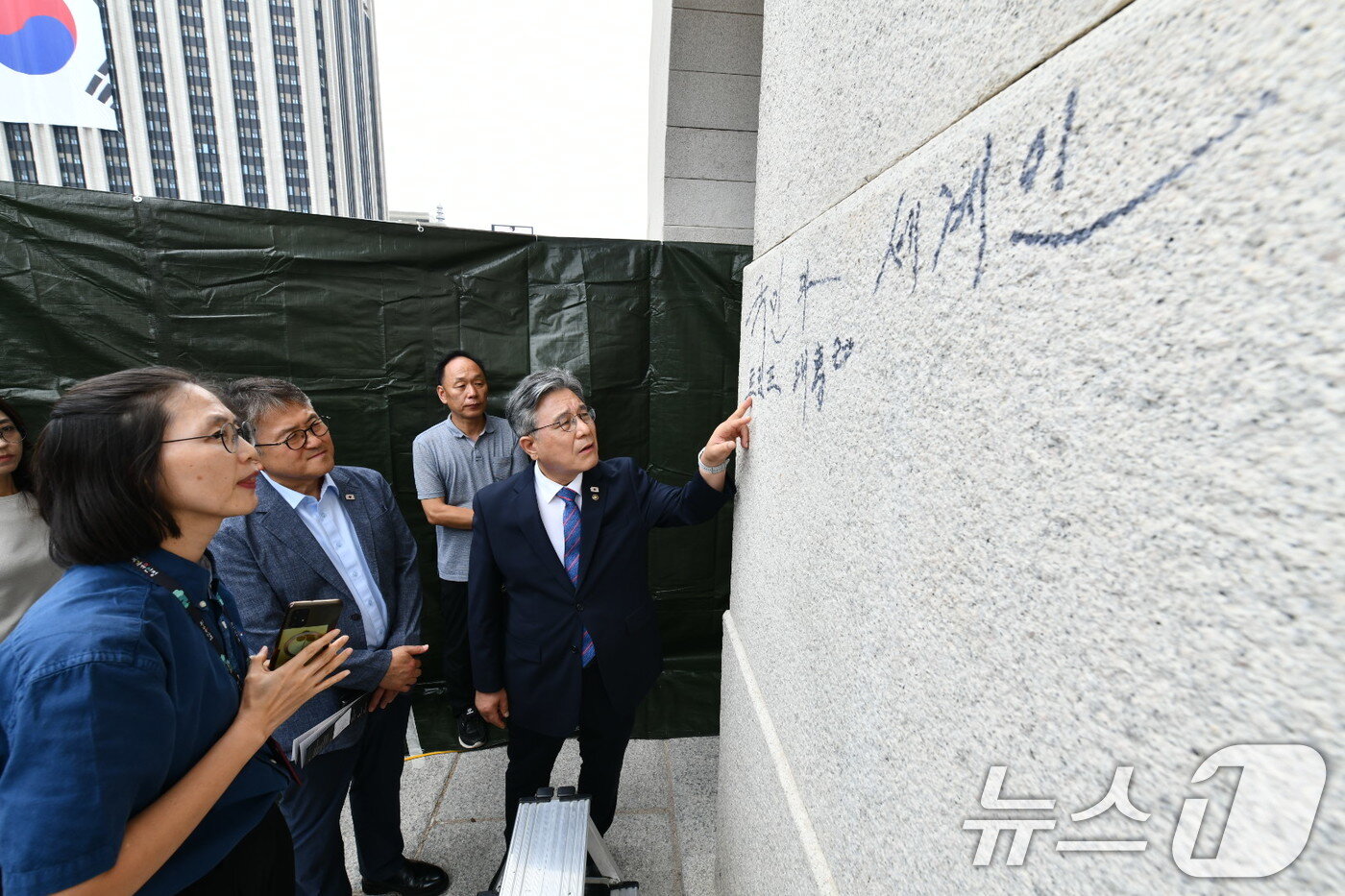 본문 이미지 - 허민 국가유산청장이 11일 오전 서울 광화문 석축의 낙서를 살펴보고 있다.  국가유산청 제공, 재판매 및 DB금지&#41;2025.8.11/뉴스1