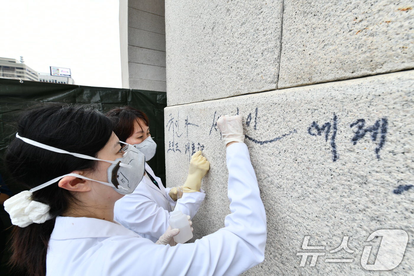 본문 이미지 - 11일 오전 국가유산청 관계자들이 서울 광화문 석축의 낙서를 지우고 있다.  &#40;국가유산청 제공, 재판매 및 DB금지&#41;2025.8.11/뉴스1