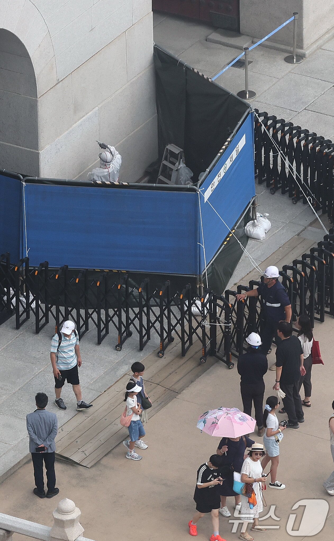 본문 이미지 - 국가유산청 관계자들이 11일 서울 경복궁 광화문 석측 낙서 흔적을 지우는 작업을 하고 있다.  2025.8.11/뉴스1 ⓒ News1 임세영 기자