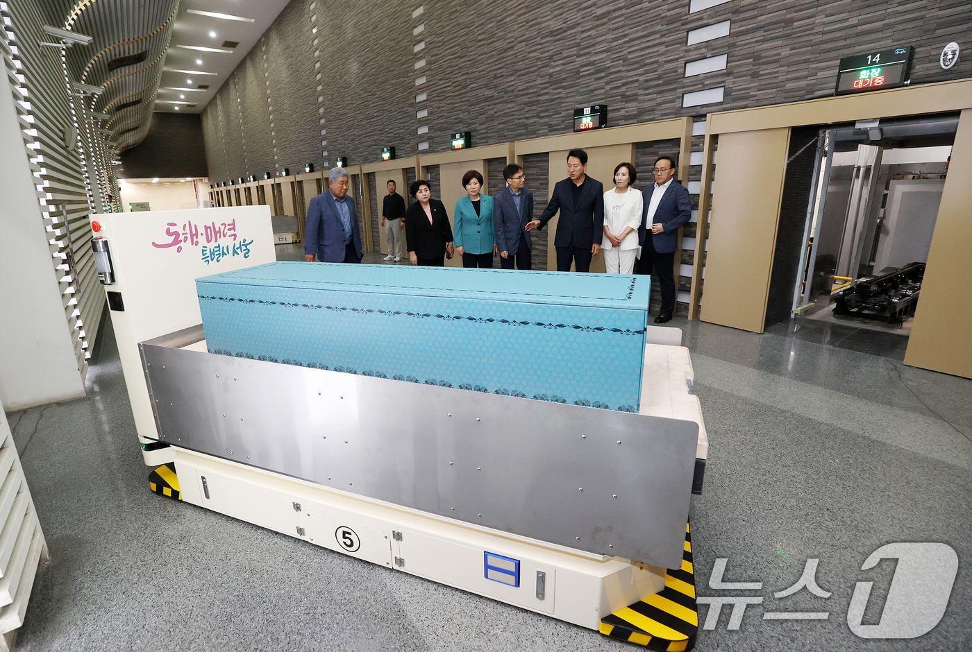 (서울=뉴스1) 김민지 기자 = 오세훈 서울시장이 11일 오후 증설 화장로 현장점검을 위해 서울 서초구 서울추모공원을 방문해 화장로 자율주행로봇(AMR) 시연을 살펴보고 있다. ( …