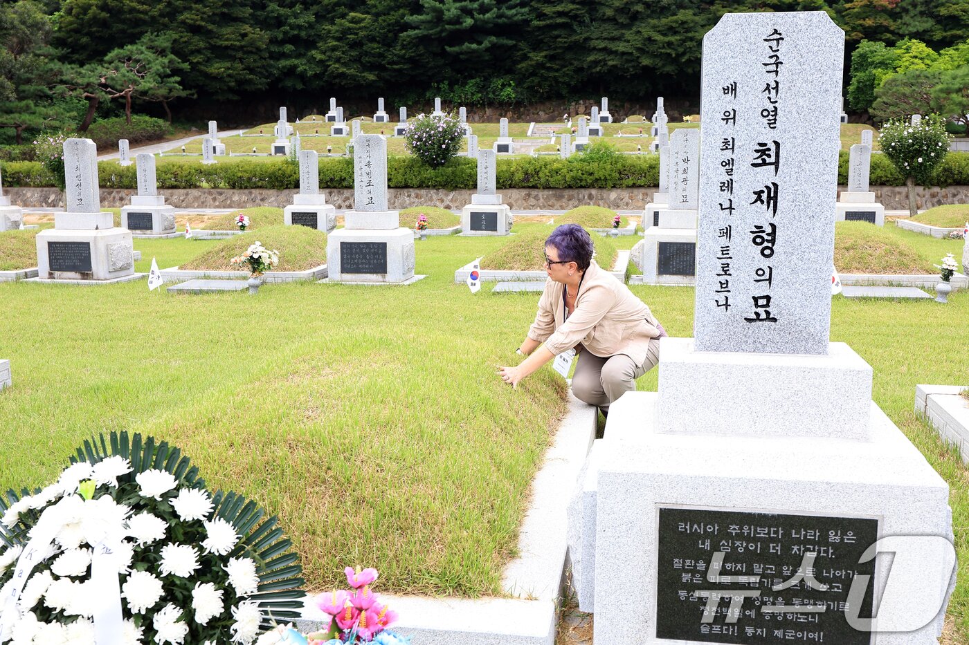 본문 이미지 - 광복 80주년을 맞아 방한한 미국을 비롯한 6개국에 거주 중인 독립유공자 후손 중 연해주 독립운동의 대부로, 한인 동포들에게 큰 사랑을 베풀어 ‘페치카&#40;러시아어로 ’난로‘&#41;’로 불린 최재형 선생&#40;1962, 독립장&#41;의 증손인 강 올가 씨가 11일 오후 서울 동작구 국립서울현충원 독립유공자묘역 최재형의 묘를 찾아 묘역을 어루만지고 있다. 2025.8.11/뉴스1 ⓒ News1 박정호 기자