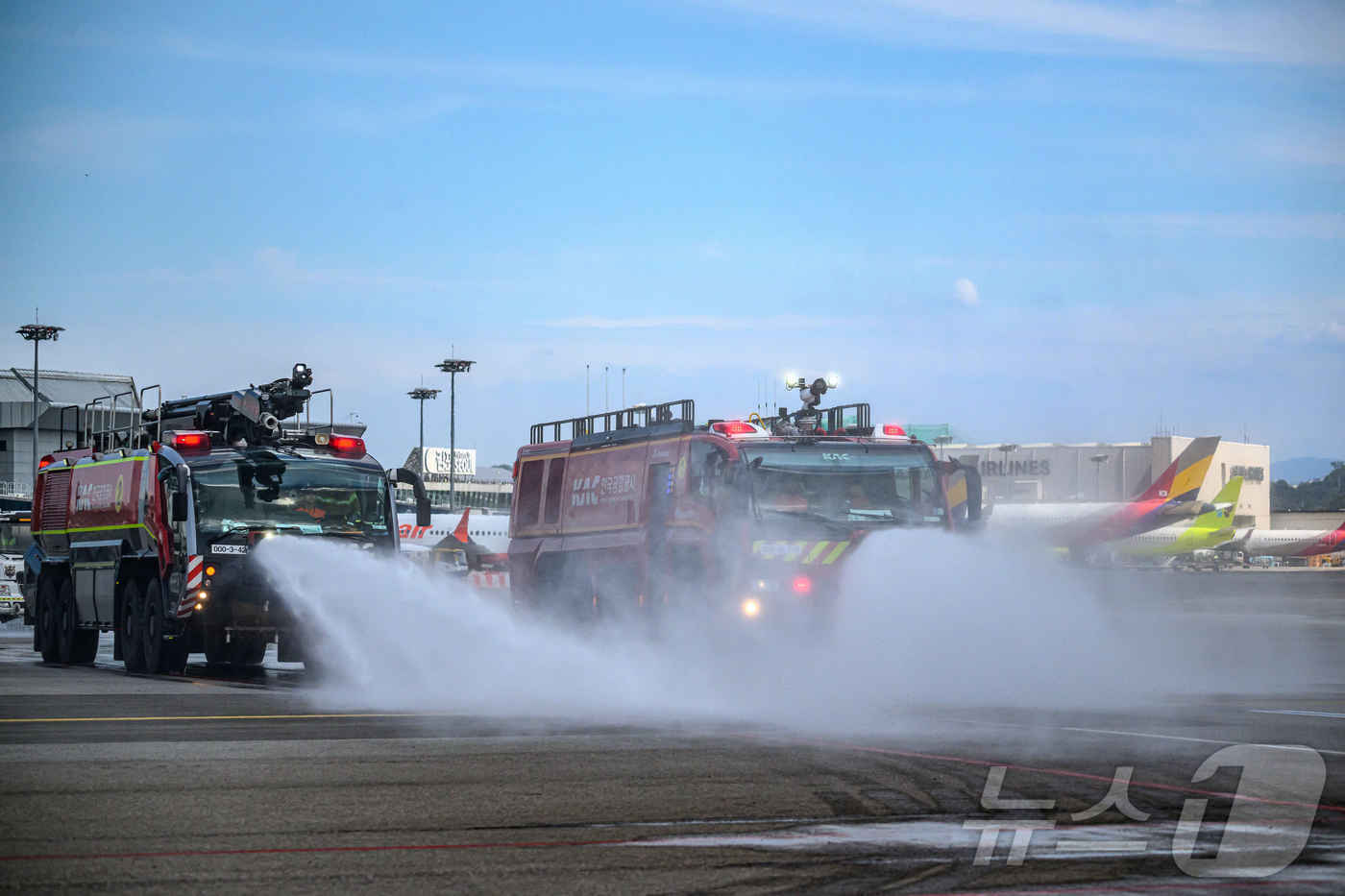 (서울=뉴스1) 박지혜 기자 = 폭염주의보가 발령된 12일 서울 강서구 방화동 김포공항 국내선 계류장에서 현장직원들이 폭염대비 항공기 안전을 위해 살수차·소방차·액상제설제 살포차 …