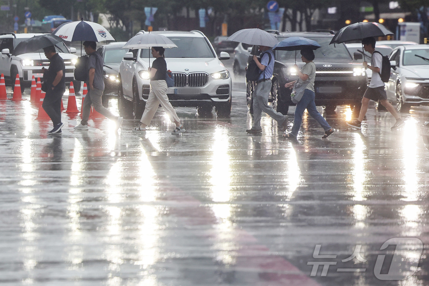 (서울=뉴스1) 민경석 기자 = 서울 지역에 호우주의보가 발령된 13일 서울 종로구 광화문네거리에서 우산을 쓴 시민들이 출근길 발걸음을 재촉하고 있다. 2025.8.13/뉴스1